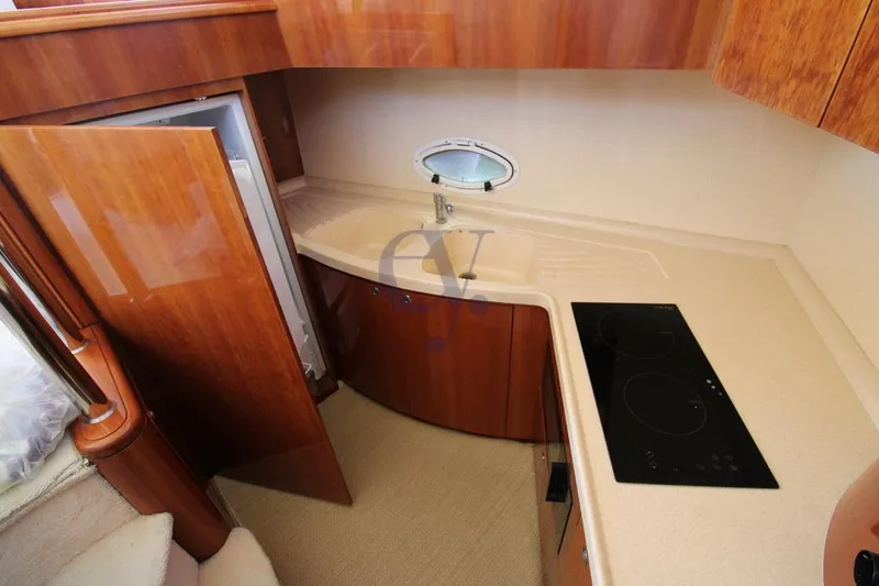 C Yacht Photos Pics 1999 Azimut 42 yacht kitchen with wood cabinetry, compact design, and modern appliances.