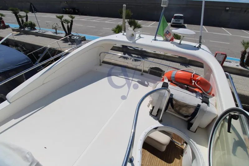 C Yacht Photos Pics 1999 Azimut 42 yacht deck with life preserver and flag, docked in marina.