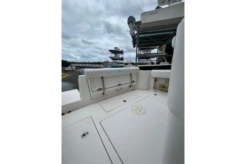 302-176 Brokerage Anthony Yacht Photos Pics 2018 Robalo R302 Center Console boat interior with storage compartments, docked under cloudy skies.