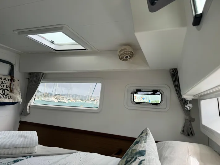 Solace Yacht Photos Pics Interior of 2020 Lagoon 42 catamaran cabin with windows and bedding.
