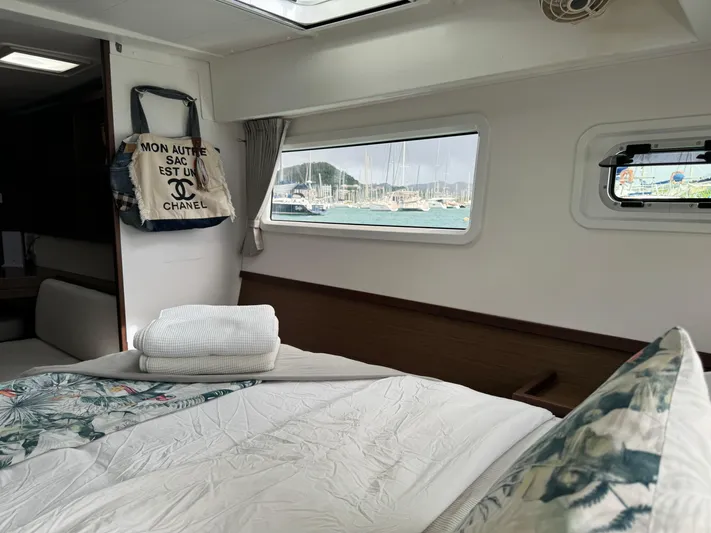 Solace Yacht Photos Pics Interior of 2020 Lagoon 42 yacht cabin with bed, window view, and decorative bag.