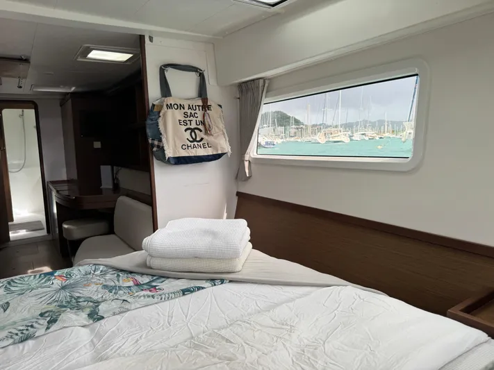 Solace Yacht Photos Pics Interior of 2020 Lagoon 42 yacht cabin with bed, window view, and decor.