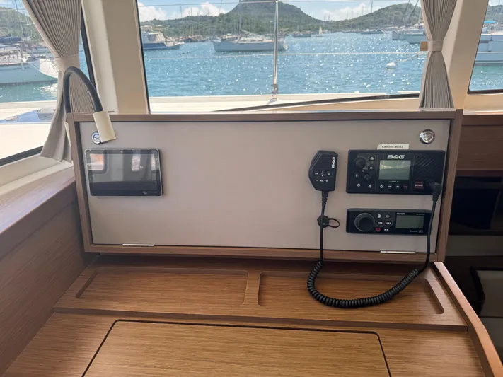 Solace Yacht Photos Pics Lagoon 42 yacht interior with navigation equipment, overlooking a scenic marina view.
