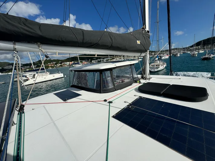 Solace Yacht Photos Pics Lagoon 42 catamaran, 2020 model, docked in a sunny marina with solar panels on deck.