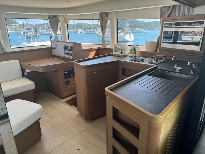 Solace Yacht Photos Pics Interior of 2020 Lagoon 42 catamaran with modern kitchen and scenic marina view.