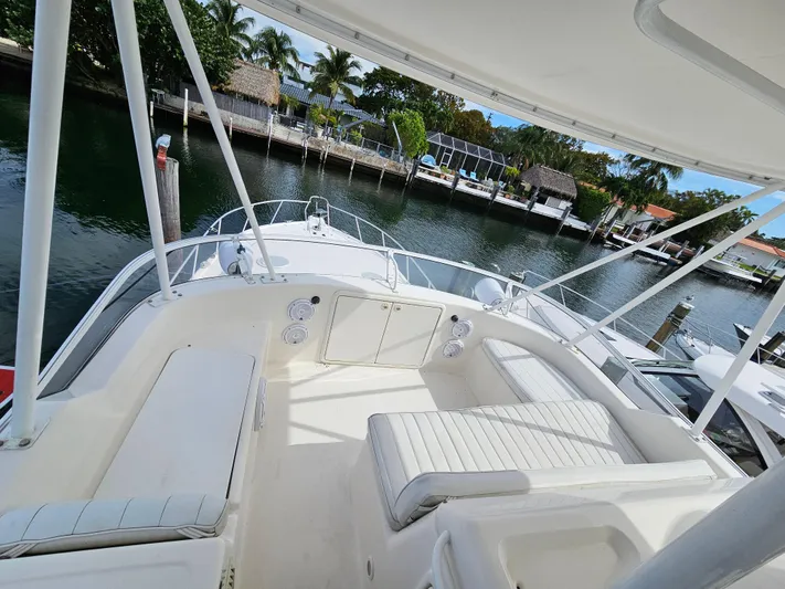  Yacht Photos Pics 2004 Riviera 42 Convertible yacht with spacious deck and seating, docked by a scenic waterfront.