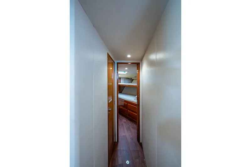 Navigator Yacht Photos Pics Narrow hallway leading to a cozy cabin with bunk beds on a 1998 Viking 50 Convertible yacht.