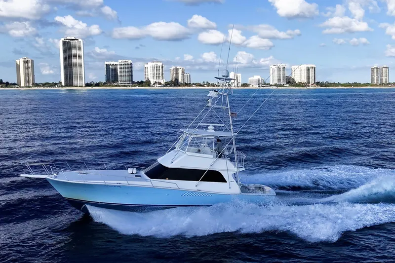 Navigator Yacht Photos Pics 1998 Viking 50 Convertible yacht cruising near city skyline on a sunny day.
