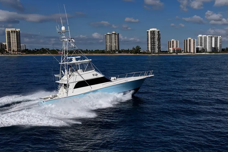 Navigator Yacht Photos Pics 1998 Viking 50 Convertible yacht cruising near coastal city skyline.