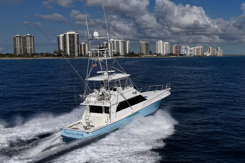 Navigator Yacht Photos Pics 1998 Viking 50 Convertible yacht cruising near coastal city skyline.