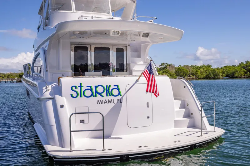 Starka Yacht Photos Pics 2009 Hatteras 64 Motor Yacht docked in Miami, featuring sleek design and American flag.