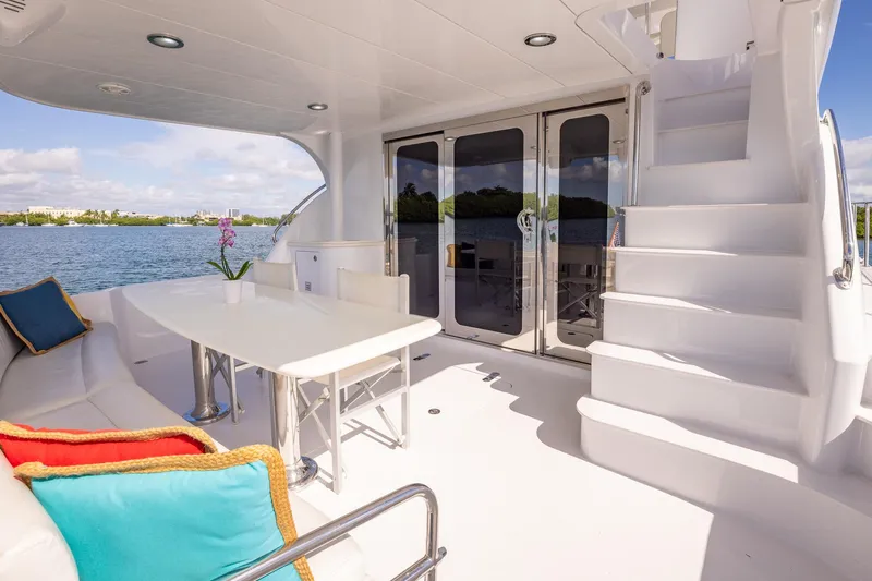 Starka Yacht Photos Pics Luxurious 2009 Hatteras 64 Motor Yacht deck with seating, table, and scenic water view.