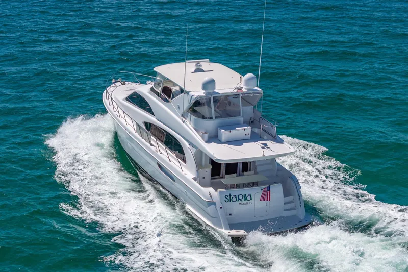 Starka Yacht Photos Pics 2009 Hatteras 64 Motor Yacht cruising on open water, rear view.
