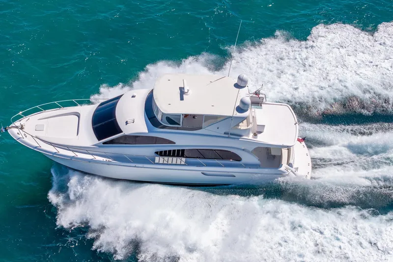 Starka Yacht Photos Pics 2009 Hatteras 64 Motor Yacht cruising on turquoise waters, aerial view.