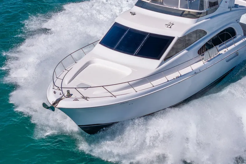 Starka Yacht Photos Pics 2009 Hatteras 64 Motor Yacht cruising on turquoise waters, showcasing sleek design.