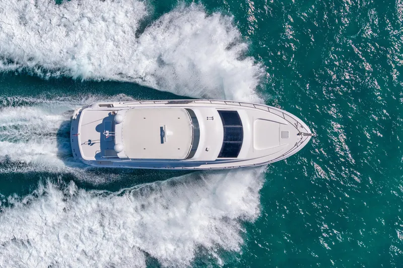 Starka Yacht Photos Pics Aerial view of 2009 Hatteras 64 Motor Yacht cruising on blue ocean waters.