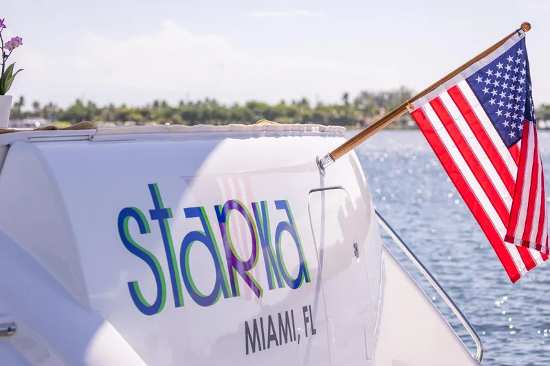 Starka Yacht Photos Pics 2009 Hatteras 64 Motor Yacht with American flag, docked in Miami, Florida.