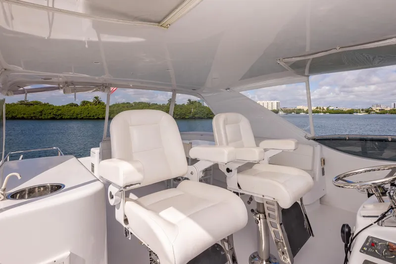 Starka Yacht Photos Pics 2009 Hatteras 64 Motor Yacht helm with white captain chairs and scenic water view.