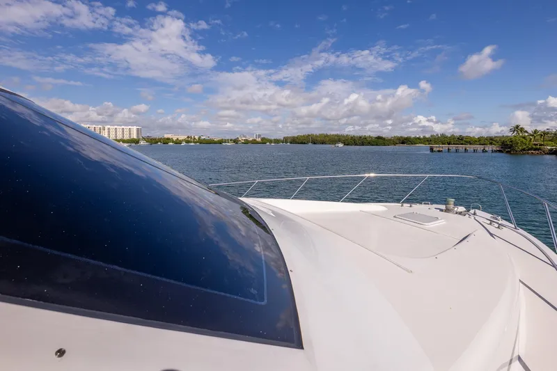 Starka Yacht Photos Pics 2009 Hatteras 64 Motor Yacht cruising on a sunny day with scenic waterfront views.