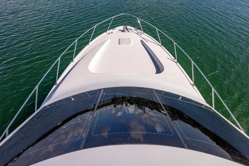Starka Yacht Photos Pics 2009 Hatteras 64 Motor Yacht bow view on calm green water.
