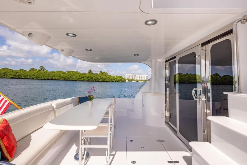 Starka Yacht Photos Pics Luxurious 2009 Hatteras 64 Motor Yacht deck with seating, table, and scenic water view.