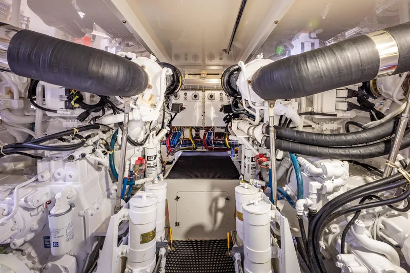 Starka Yacht Photos Pics Engine room of 2009 Hatteras 64 Motor Yacht, showcasing complex machinery and piping.