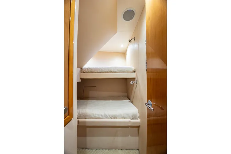 Starka Yacht Photos Pics Bunk beds in 2009 Hatteras 64 Motor Yacht cabin, featuring wooden finishes and cozy lighting.