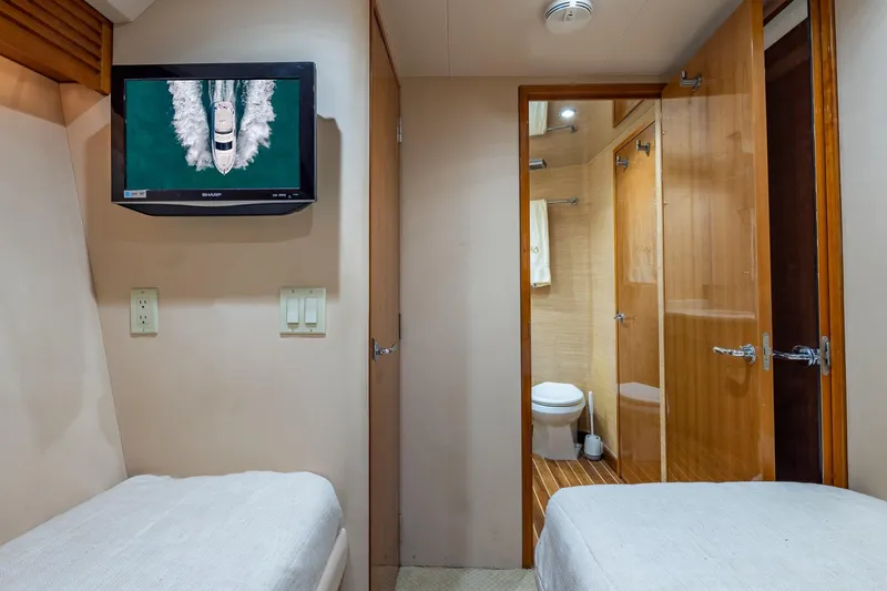 Starka Yacht Photos Pics Interior of 2009 Hatteras 64 Motor Yacht with twin beds, TV, and bathroom.