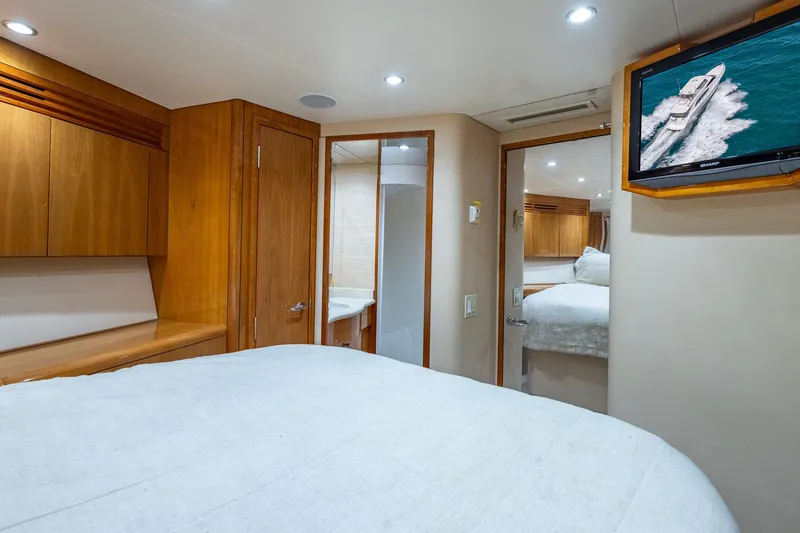Starka Yacht Photos Pics Luxurious bedroom interior of 2009 Hatteras 64 Motor Yacht with wood accents and TV.