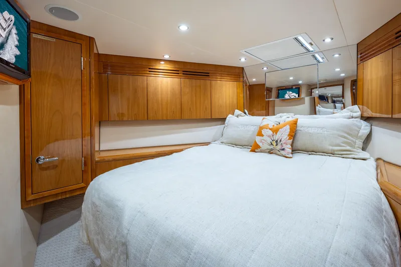 Starka Yacht Photos Pics Luxurious bedroom interior of 2009 Hatteras 64 Motor Yacht with wood cabinetry and cozy bedding.