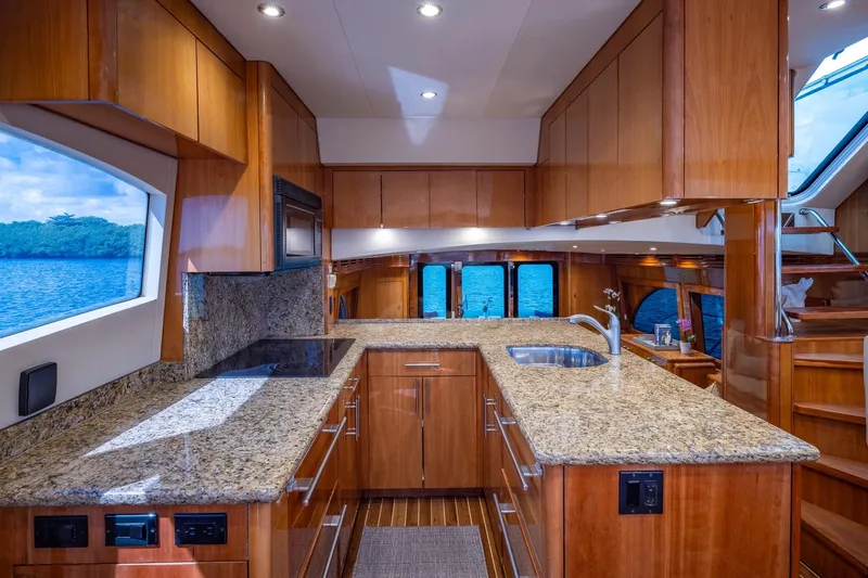 Starka Yacht Photos Pics Luxurious kitchen interior of 2009 Hatteras 64 Motor Yacht with granite countertops and wood cabinetry.