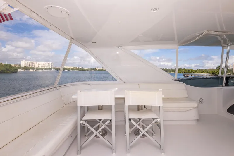 Starka Yacht Photos Pics 2009 Hatteras 64 Motor Yacht deck with seating, overlooking serene waterfront view.