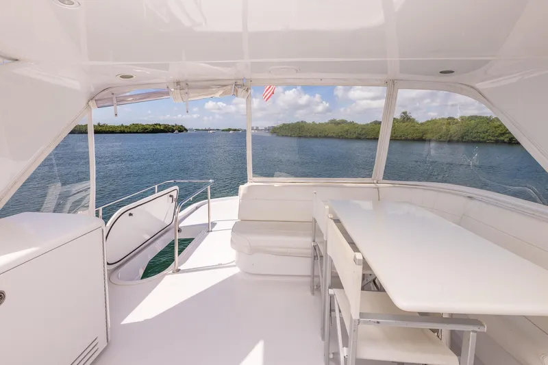 Starka Yacht Photos Pics 2009 Hatteras 64 Motor Yacht interior with seating and table, overlooking serene water view.
