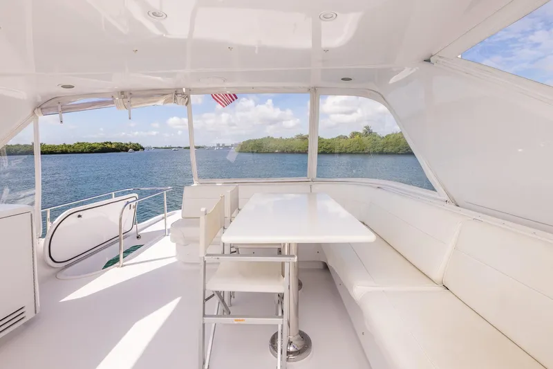 Starka Yacht Photos Pics 2009 Hatteras 64 Motor Yacht interior with white seating, table, and scenic water view.