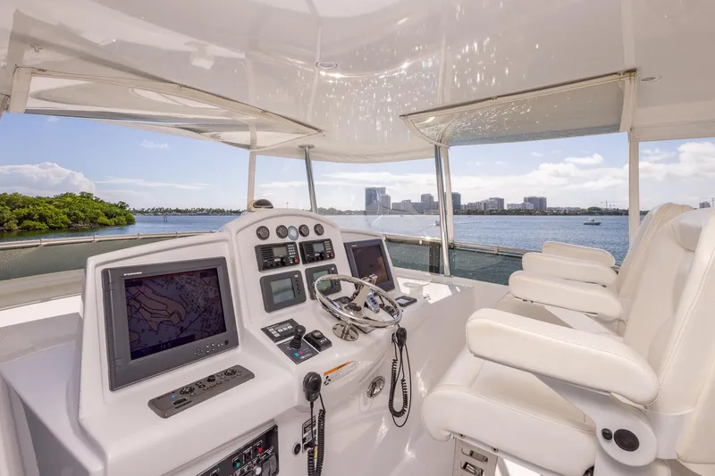 Starka Yacht Photos Pics Helm of 2009 Hatteras 64 Motor Yacht with navigation screens and white seating.