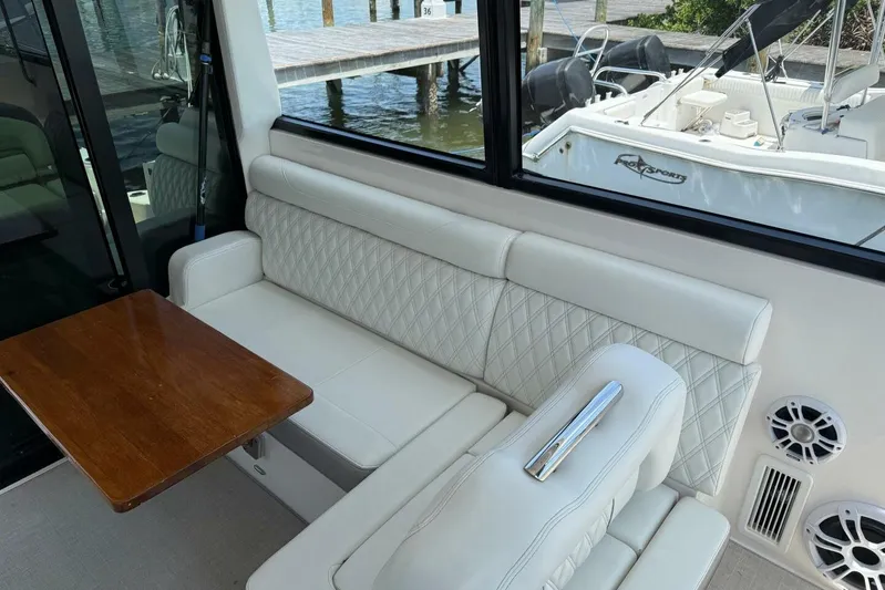  Yacht Photos Pics 2021 Regal 36 XO yacht interior with white seating and wooden table.