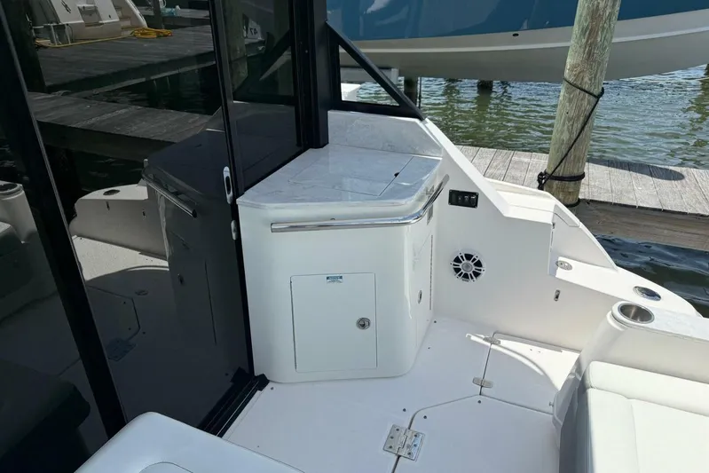  Yacht Photos Pics 2021 Regal 36 XO boat interior with sleek white cabinetry and seating by the dock.