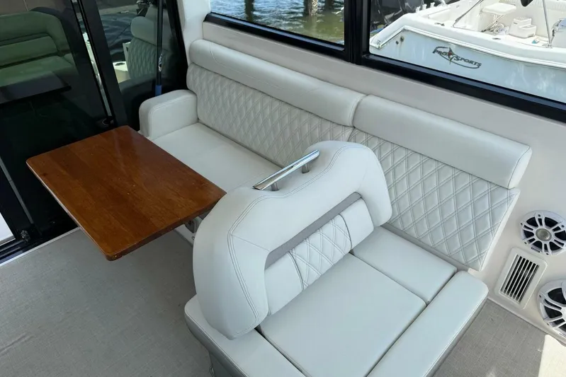  Yacht Photos Pics 2021 Regal 36 XO boat interior with white quilted seating and wooden table.