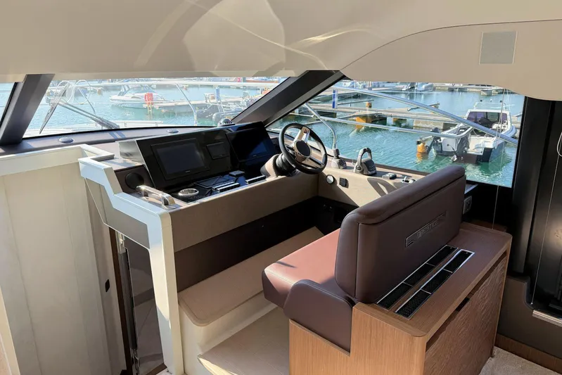  Yacht Photos Pics Luxurious 2025 Prestige F4.9 yacht cockpit with modern controls and marina view.