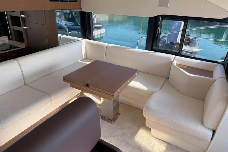  Yacht Photos Pics Luxurious interior of 2025 Prestige F4.9 yacht with elegant seating and wooden table.