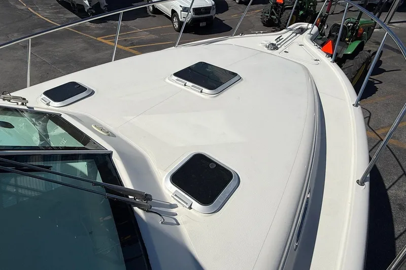  Yacht Photos Pics 2007 Pursuit OS 335 Offshore boat deck with hatches and railing in a parking area.