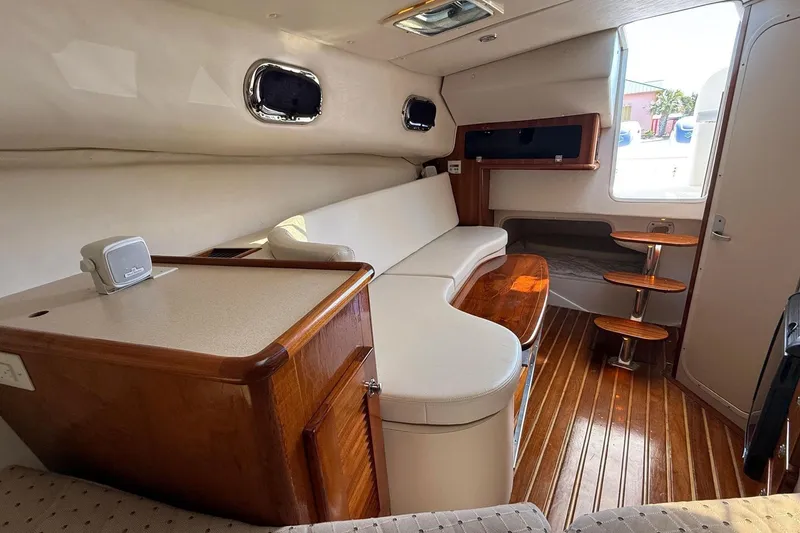  Yacht Photos Pics 2007 Pursuit OS 335 Offshore cabin interior with wooden flooring and seating area.