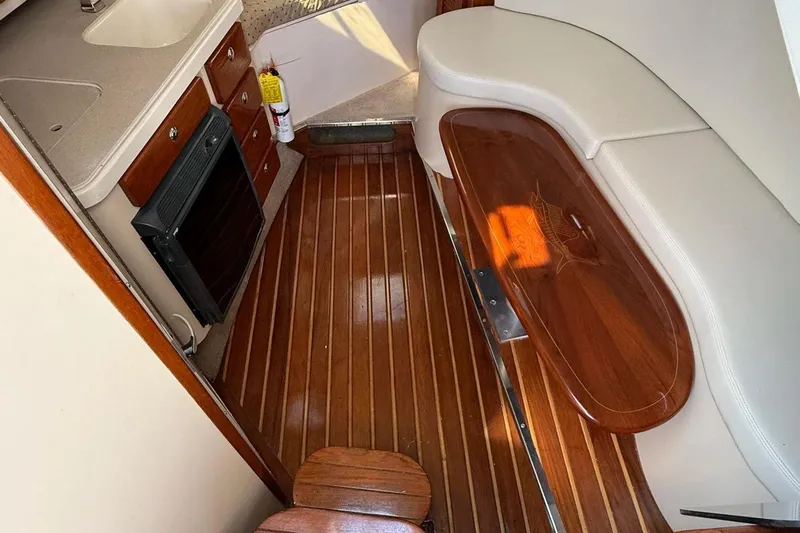  Yacht Photos Pics 2007 Pursuit OS 335 Offshore cabin interior with wood flooring and seating area.