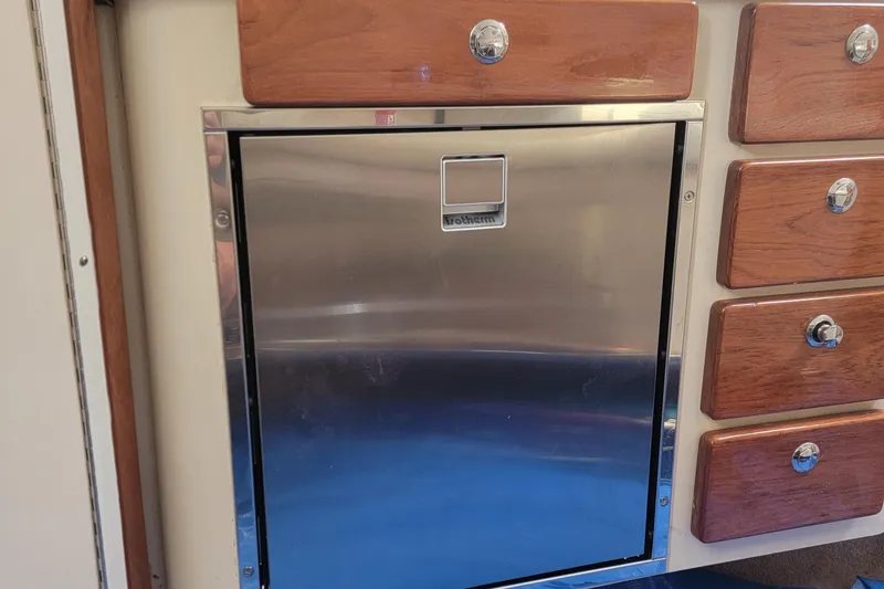  Yacht Photos Pics Stainless steel fridge and wooden drawers in 2007 Pursuit OS 335 Offshore boat interior.