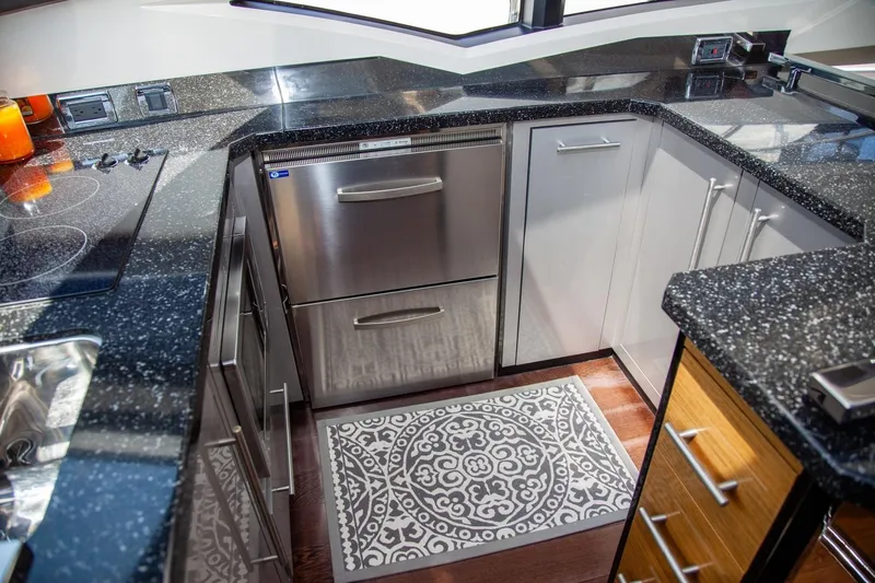  Yacht Photos Pics Modern kitchen in 2009 Marquis 500 Sport Coupe with stainless steel appliances and patterned rug.