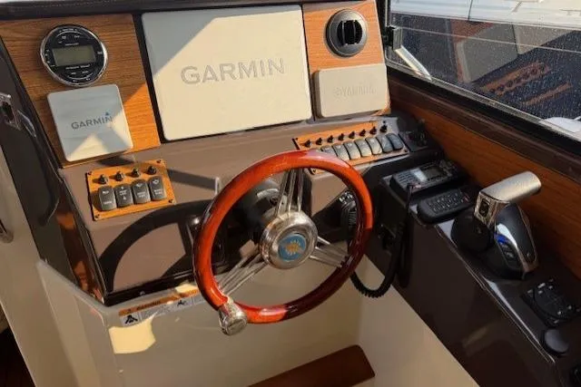 Evangaline Yacht Photos Pics 2022 Ranger Tugs R-25 helm with Garmin navigation, wooden steering wheel, and control panel.