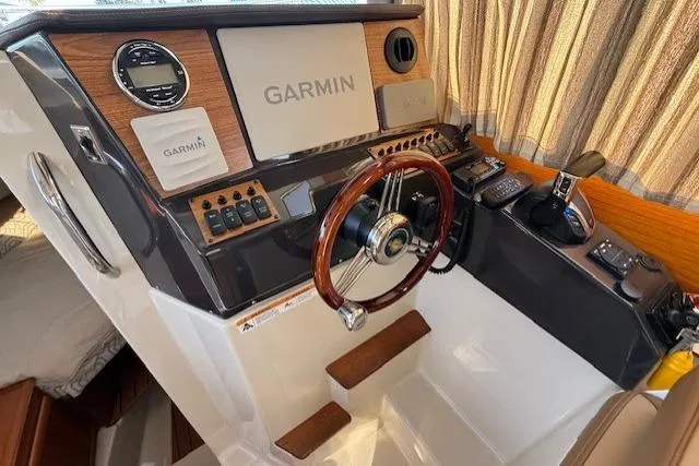 Evangaline Yacht Photos Pics 2022 Ranger Tugs R-25 helm with Garmin navigation, wood accents, and modern controls.