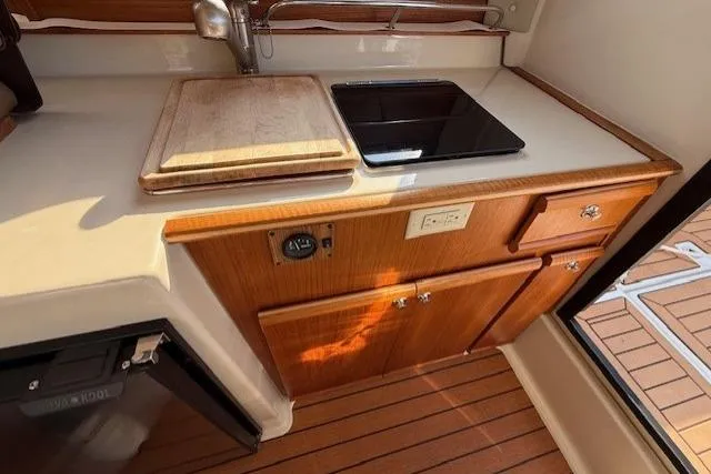 Evangaline Yacht Photos Pics 2022 Ranger Tugs R-25 galley with wooden cabinetry, sink, and stove.