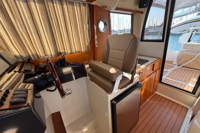 Evangaline Yacht Photos Pics Interior of 2022 Ranger Tugs R-25 boat with helm, seating, and wood accents.