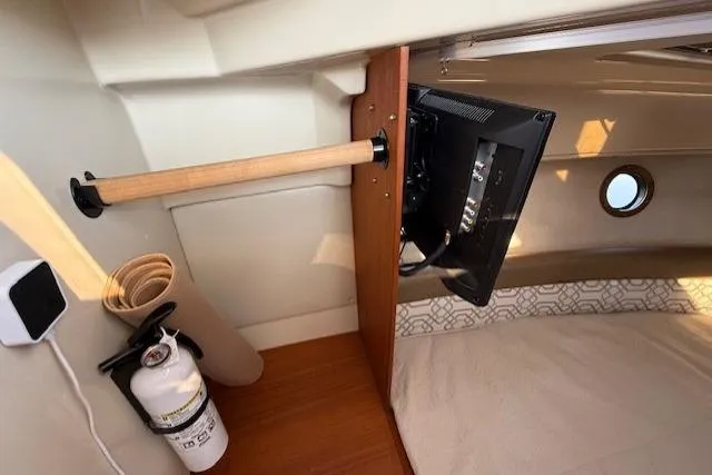 Evangaline Yacht Photos Pics 2022 Ranger Tugs R-25 interior with mounted TV, fire extinguisher, and porthole window.